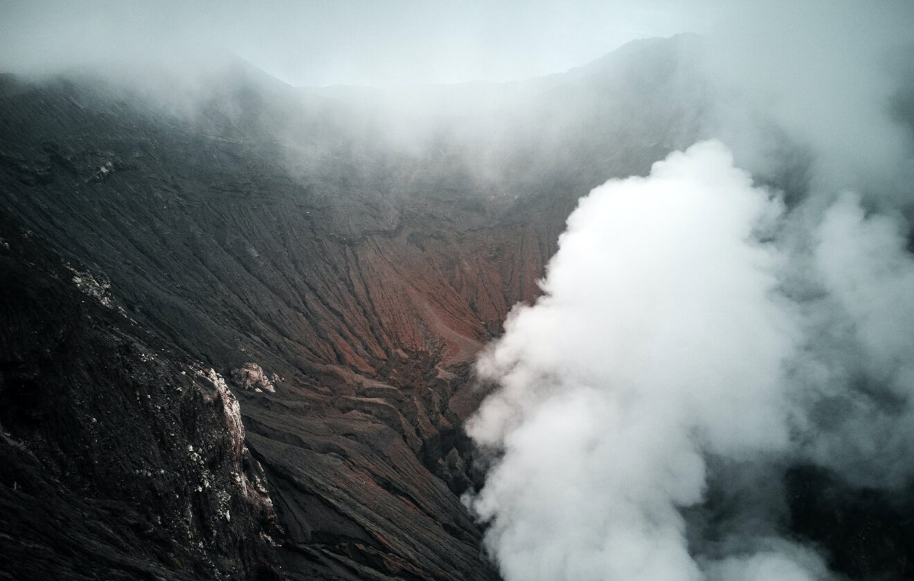 Steaming Volcanic Crater Amid Misty Mountain Surroundings 1